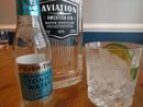 A gin and tonic beside a bottle of Aviation gin and Fever Tree Mediterranean tonic water