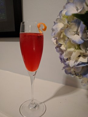 Bright red drink in a champagne flute